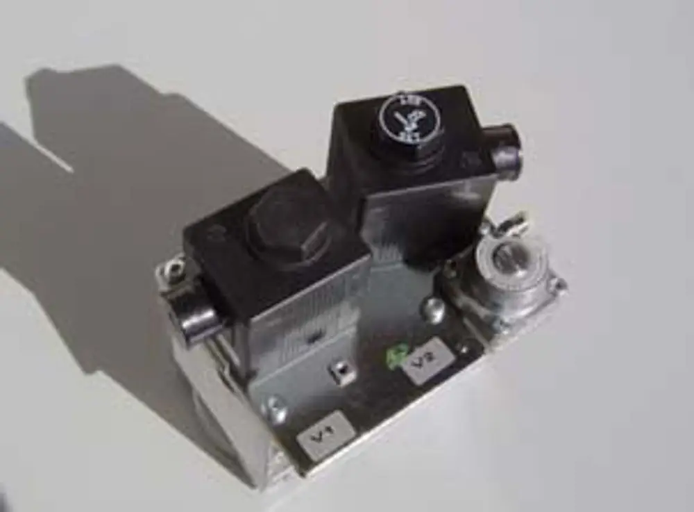 Gasventil der Marke Remeha, metallische Basis mit zwei schwarzen Ventilen, einem Anschluss und mehreren Beschriftungen, auf einem hellen Hintergrund platziert.